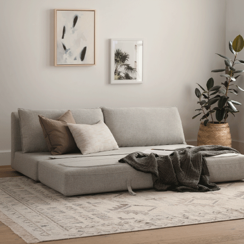 Armless sofa bed styled with colorful throw pillows.